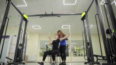 Kendini adamış bir kadın, erkek ve çocuğa canlı bir spor salonundaki egzersizlerde rehberlik eder, teknikler gösterir ve onları spor amaçlarına ulaşmaları için cesaretlendirir.