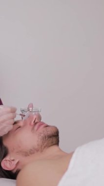 Güzellik salonunda, bir kadın bir erkeğin koluna iğne yapıyor. Onun koluna yaptığı nazik jestle rahatça gülümsüyor, bir vizyon tedavisi garantiliyor. Dikey video