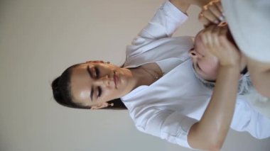 Masör, gözleri kapalı yatan olgun bir kadına çift çene tedavisi uyguluyor. Yüksek kalite 4k görüntü