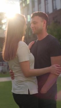 Beyaz tişörtlü, uzun sarı saçlı bir kız ve siyah tişörtlü bir adam sarılıp konuşuyor. Yüksek kalite 4k görüntü