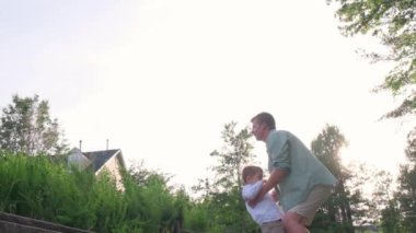 Yürek ısıtan bir video, parkta bir çocuğu kaldıran, onların bağlarını ve eğlenceli ilişkilerini vurgulayan ve aile eğlencelerini resmeden bir adamı gösteriyor.