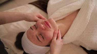 Bir kadının gençleştirici yüz tedavilerini sevdiği, rahatlatıcı masajlarla rahatlattığı, ışıltısını ve sükunetini arttıran bir spa ortamı.