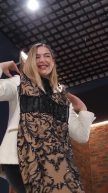 Çekici, narin sarışın gelinliğini gelinlik butiğinde seçiyor. Parti, düğün, doğum günü için gece kıyafeti seçimi. Dikey video