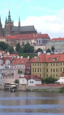 Prag 'ın Eski Kasabası' nda dikey video. Prag nehri. Kırmızı çatılı binalar. Prag Katedrali