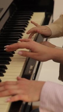 Bir kadın ve bir çocuk, öğrenmenin ve uyum içinde müzik çalmanın sevincini gösteren yürek ısıtan bir videoda birlikte piyano çalıyorlar.