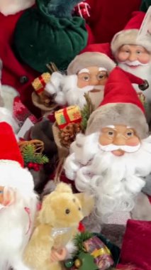 Noel Baba bebeklerinin tuhaf bir yığını ve bir masanın üzerindeki süslemeler bayram ruhunu yansıtıyor. Bu büyüleyici düzenleme neşe ve kutlamayı çağrıştırıyor.