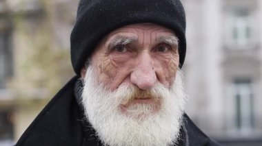 Bu videoda, siyah şapkalı yaşlı ve orta yaşlı adamların etkileyici görüntüleri gösteriliyor. Kameraya bakışlarına odaklanıyorlar.