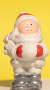 Bu videoda Noel heykelcikleri gösteriliyor. Aralarında sarı bir zemin üzerinde kartopu tutan sevimli bir Noel Baba da var. Şenlik ayrıntılarını kaydediyor.