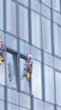Dikey video işçilerinin uzun bir gökdelende camları vardır. Riskli bir iş, metropoldeki bir gökdelenin camlarını yıkamaktır..