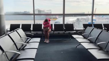 Havaalanı bekleme odasında sırt çantalı genç bir kadın. Yüksek kalite 4k görüntü