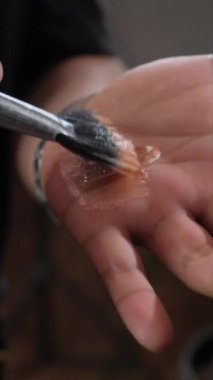 Makyaj sanatçısı bir fırçayla el avucuna fondöten kremi sürer. Yüksek kalite 4k görüntü