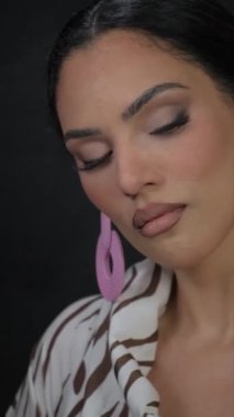 Büyük pembe küpeli esmer bir model kameraya poz veriyor. Yüksek kalite 4k görüntü