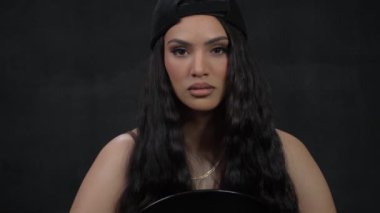 Dalgalı saçlı, omuzları çıplak ve boynunda altın bir zincir olan esmer bir kadın bir fotoğrafçıya poz veriyor. Yüksek kalite 4k görüntü