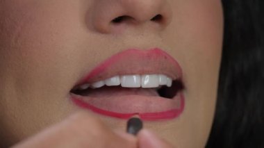 Makyaj sanatçısı modelin dudaklarını kozmetik kalemle takip eder. Yüksek kalite 4k görüntü