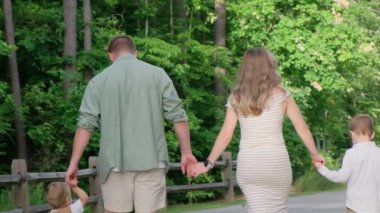 Sevgi dolu bir aile, sakin bir ormanlık alanda el ele dolaşır, doğal güzelliğin tadını çıkarır ve birlikte güzel anılar yaratır.