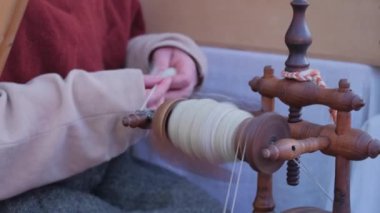 Tekstil atölyesinde koyun yünü örmek için iplik makinesini kullanan yakın plan işçi kadın. Yüksek kalite 4k görüntü