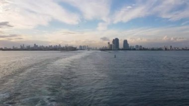 Sudan manzaralı bir şehirde, sakin dalgalarla ışıl ışıl parlayan bir ufuk çizgisinin çarpıcı hava ve yakın çekim görüntüleriyle bir yolculuk yaşayın.