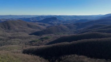 Bu hava görüntüsü bir dağ sırasının nefes kesici güzelliğini gözler önüne seriyor, görkemli tepeler ve dingin, canlı manzaralı vadiler.