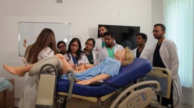 Bir grup Hintli öğrenci bir mankenin ebelik eğitiminden geçiyor. Jinekoloji. Yüksek kalite 4k görüntü