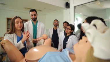 Bir kadın doğum uzmanı-jinekolog öğretmen öğrencilerin manken üzerinde doğum yaptıklarını gösteriyor. Tıp öğrencilerinin eğitimi. Yüksek kalite 4k görüntü
