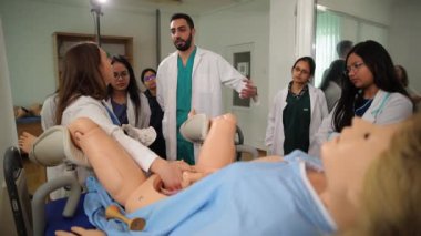 Bir grup jinekoloji öğrencisi bir manken üzerinde doğum süreçleri üretmek için pratik egzersizler yapıyor. Klinikte. Yüksek kalite 4k görüntü