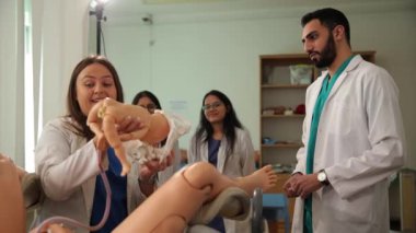 Öğretmen bir çocuk mankeni tutuyor. Doğum simülasyonu