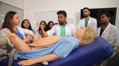 Jinekoloji öğrencilerinin manken üzerinde doğum eğitimi almaları için pratik bir eğitim. Klinikte. Yüksek kalite 4k görüntü