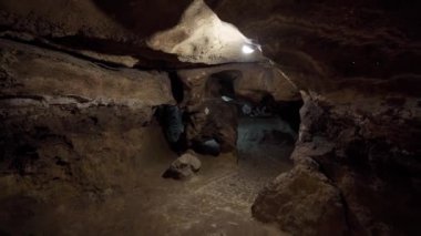 Yapay ışıklandırmalı bir yeraltı mağarasının ilginç bir görüntüsü. Erişilemez yerlerdeki yeraltı dünyasının keşfi. Jeolojik keşif gezisi