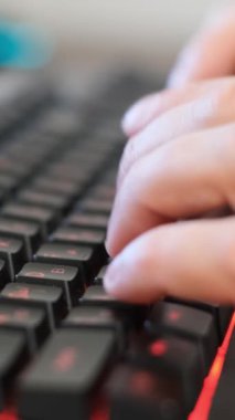 Bu video, birinin parlak bir klavyeye yazı yazıp, ritmik parmak hareketlerini ve kırmızı tuşlarını vurguluyor, üretkenliği somutlaştırıyor.