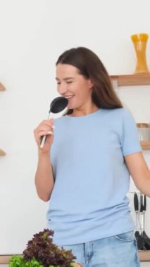 Neşeli bir kadın mutfağını müzik ve neşe ile doldurur. Yemek yaparken, kepçe ve spatula gibi aletlerle dans ederken ve şarkı söylerken, yaratıcılığını gösterir.