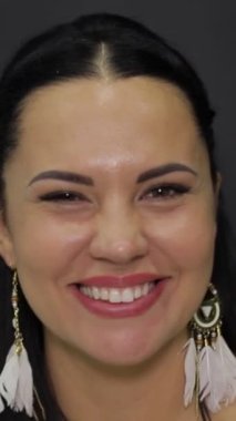 Bu video, kendine güvenen, neşeli, gülümsemesini ve zarif küpelerini ifade eden güzelliği ve pozitifliği vurgulayan bir kadını içeriyor.