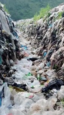 Doğanın plastik kirliliği, çöplerle dolu bir arazide akan akıntıyı gösteriyor, doğayı kurtarmak için harekete geçiyor.