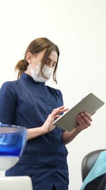 Bu video, klinik bir ortamda hasta bakımına ve modern teknolojiye olan bağlılığını vurgulayan tablet ve pano kullanan bir dişçiyi gösteriyor.