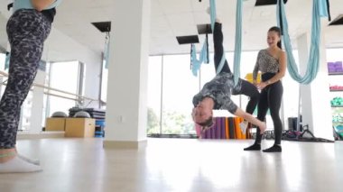 Beden eğitimi öğretmeni, genç bir bayana hava temizleme egzersizi yapmayı öğretiyor. Spor salonu. Yüksek kalite 4k görüntü