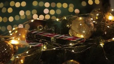 Bu şenlikli video Noel ruhunu güzel dekore edilmiş bir ağacın, renkli ışıkların, hediyelerin ve şeker kamışlarının yakın çekimleri ile sergiliyor.