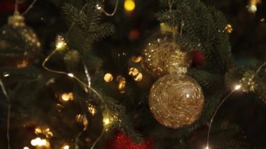 Renkli süslerle süslenmiş bir Noel ağacının yakın çekimi ve parıldayan ışıklar, tatil sezonunun sıcaklığını ve neşesini yansıtıyor.