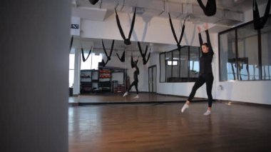 Spor hareketleri yapan genç bir kız modern ve iyi donanımlı bir spor salonunda fitness için tasarlandı..