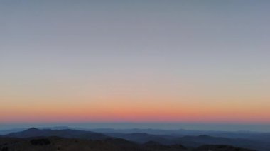 Bu çarpıcı bir alacakaranlık manzarası güzel yumuşak renk eğimlerini uzak tepelerin üzerinde sergiliyor.