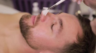 Bir adam lüks bir kaplıcada derin bir yüz tedavisiyle eğleniyor. Etkili cilt yenilenmesi, canlandırma ve rahatlama için tasarlanmış..