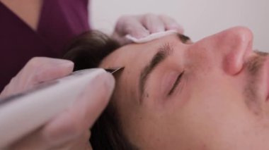 Bir adam spa salonunda profesyonel yüz bakımı yaptırıyor..