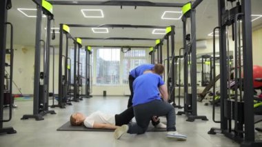 Kendini adamış iki antrenör, iyi hazırlanmış bir spor salonunda yoğun bir eğitim sırasında tek bir kişiye yardım ediyor..