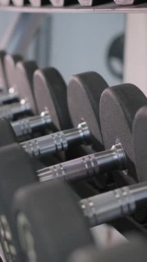Spor salonunda dambılları kaldıran kadına yaklaş. Fitness kas, yaşam tarzı ve kadın sağlığı kavramını geliştirme egzersizleri.