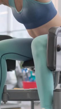 Spor salonunda bacak kaslarını çalıştıran aktif bir kadın. Spor giyim sektöründe spor modelliği yapmaktan keyif alıyorum. Yakın plan..