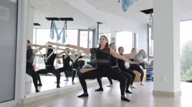 Genç kadınlar aynanın önünde taşaklarıyla antrenman yaparlar. Spor salonu. Yüksek kalite 4k görüntü