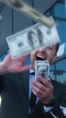 Bir iş adamı, finansal başarı ve refahın güçlü bir sembolü olan parayı memnuniyetle kucaklıyor..