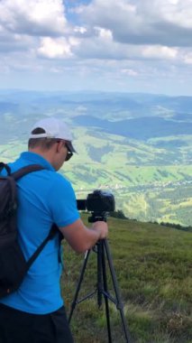 Yetenekli bir fotoğrafçı muhteşem bir dağ manzarası yakalamak için kamerayı tripoda yerleştirir.