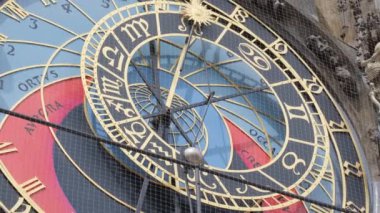 Karmaşık zodyak işaretleri ve ayrıntılı tasarım unsurları olan çarpıcı astronomik bir saate yakın plan..