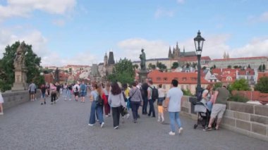 Turistler, yoğun bir Prag köprüsünde güzel manzaraların keyfini çıkararak şehirleri eşsiz cazibe ve özle kaplıyorlar. Prag, Çek Cumhuriyeti 22 Eylül 2024.