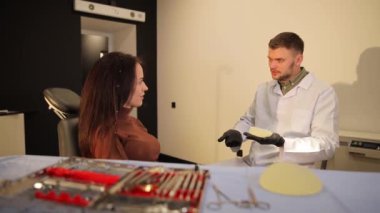Göğüs büyütme uzmanı modern klinikteki hastalarla farklı tedavi seçeneklerini tartışıyor..