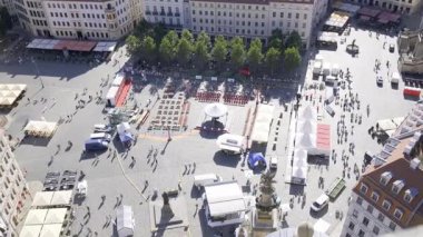 Hareketli pazar meydanı renkli tezgahlar, uzun ağaçlar ve bir Avrupa şehrinin hayat dolu atmosferinden hoşlanan insanlarla dolu..